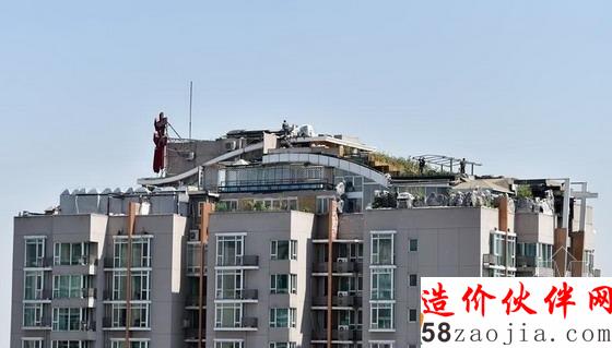 人济山庄B座楼顶被种中上了植物,有工人正在施工