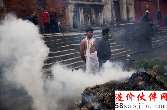 在对死者的纪念典礼上,幸存者站在一旁面露悲伤