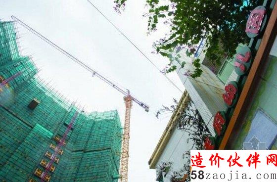 工地与幼儿园仅一墙相隔,上空是塔吊吊臂